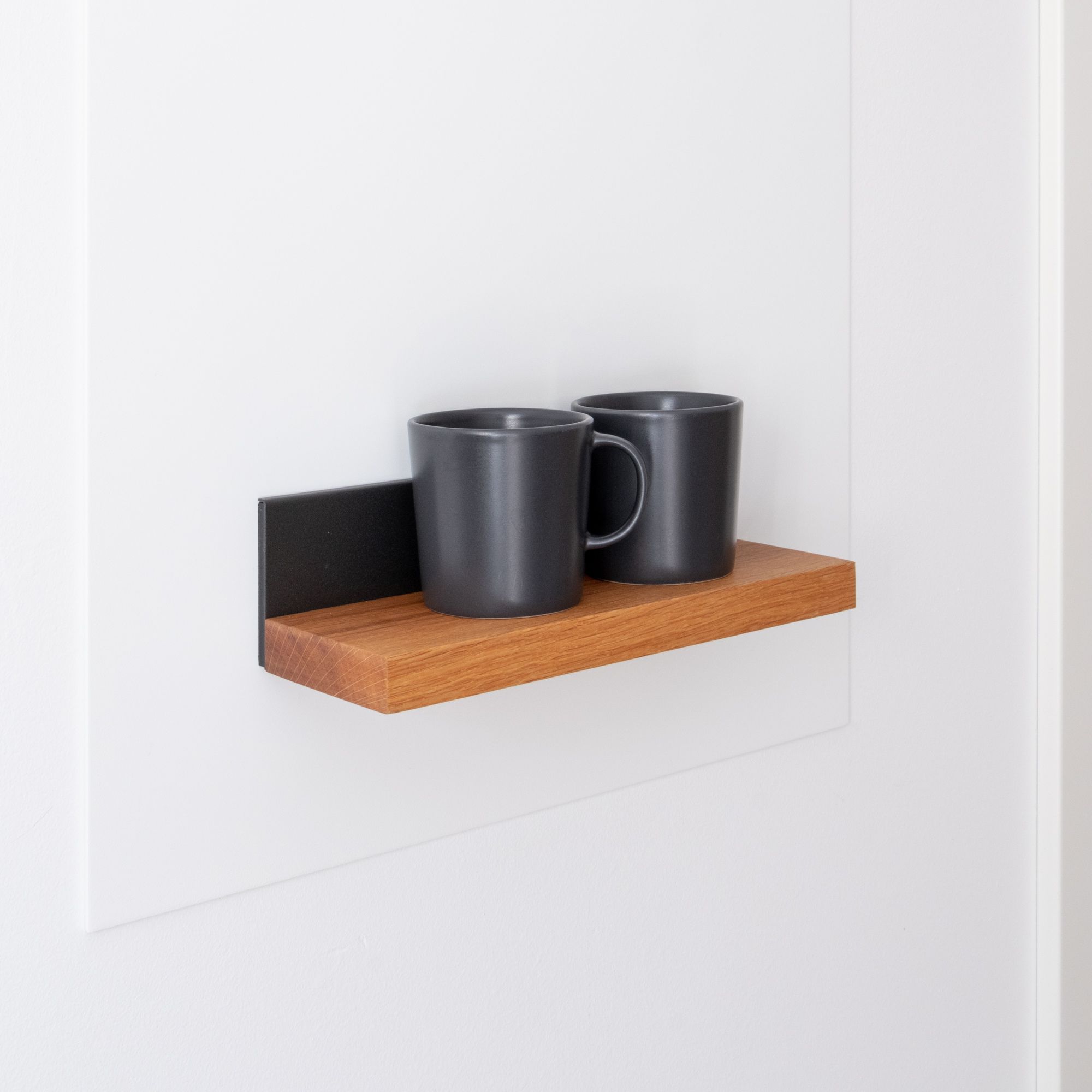 Magnetisches Holzregal mit schwarzer Rückwand und zwei Tassen an der Wand